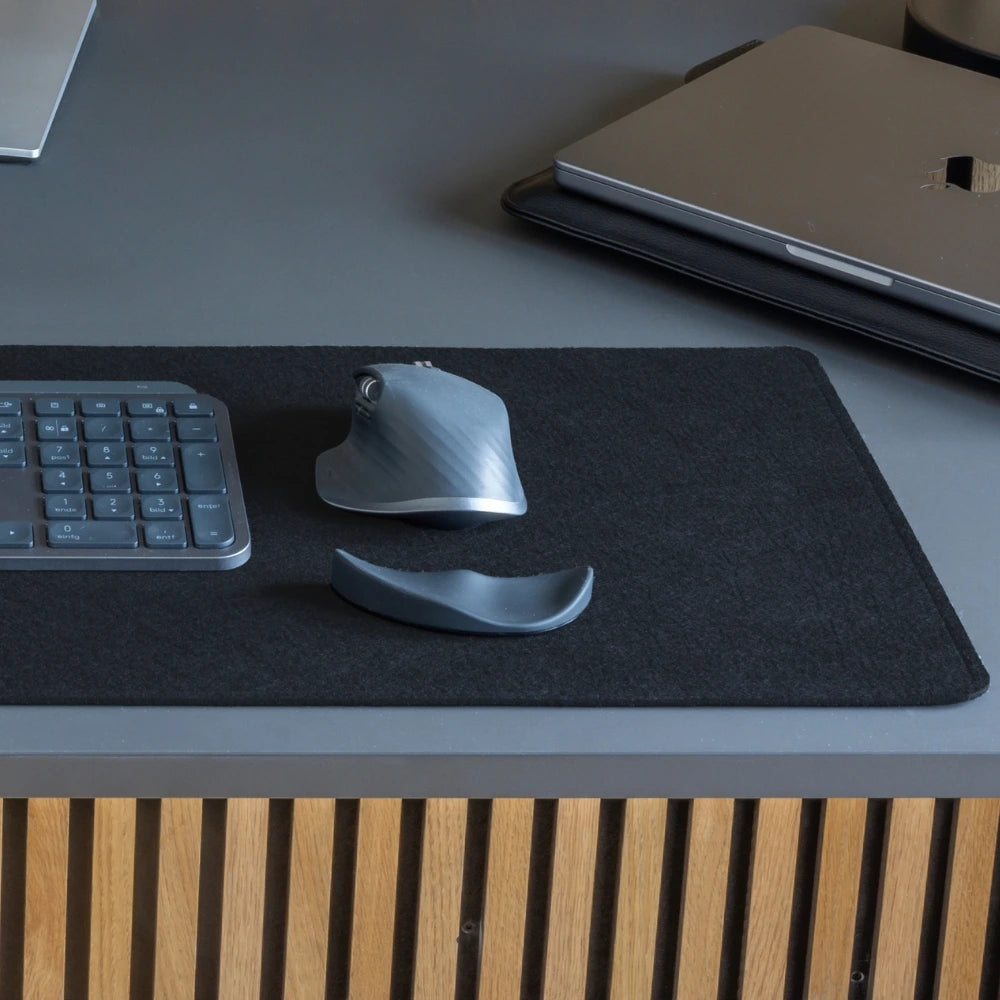 Arbeitsplatz-Setup mit schwarzer Schreibtischunterlage, ergonomischer ERGOSLIDE Handgelenkauflage, Maus und Tastatur. Die Handgelenkauflage und Schreibtischunterlage bieten Komfort und Unterstützung für produktives Arbeiten.